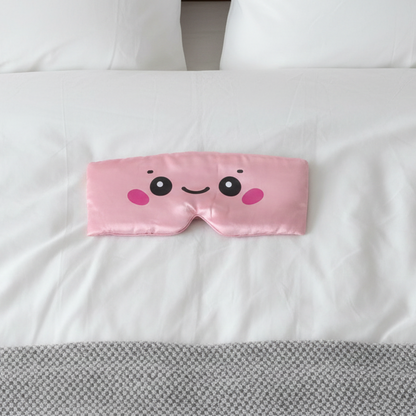 Pink cartoon face mask on a white pillow with gray blanket